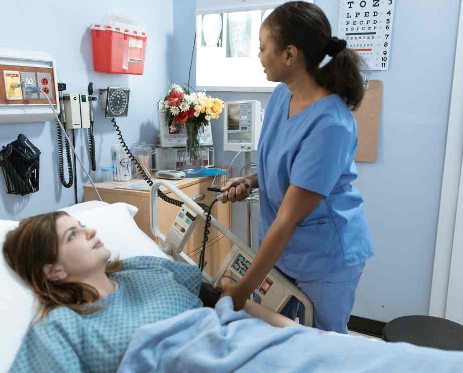 Nurse helping a patient in their hospital bed