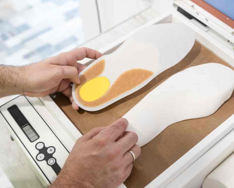 Podiatrist moulding an insole to help a patient